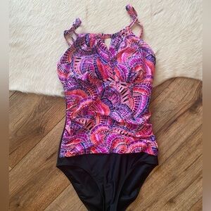 Krista brand one-piece swimsuit with a colorful, patterned top and black bottom